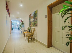 A hallway with a dining area, a painting, and a door. - Jaguar Condos Cozumel The Private Group Villa / Casa 1-24 w/2 pools Downtown (Cozumel)