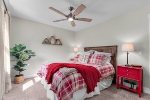 A bedroom with a bed, a ceiling fan, a nightstand, a lamp, a plant, and a wall-mounted shelf. - Treehouse on Daly | Steps to Main St & Trolley (Park City)
