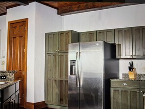 A kitchen with wooden cabinets, a stainless steel refrigerator, and a granite countertop. - Wyndham Glacier Canyon at the Wilderness Wisconsin Dells Waterpark. 3 br Condo (Baraboo)