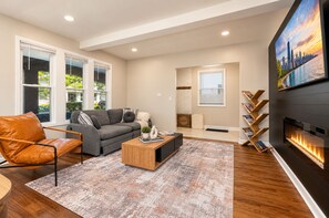 Un salon moderne avec un canapé, une table basse et une cheminée.