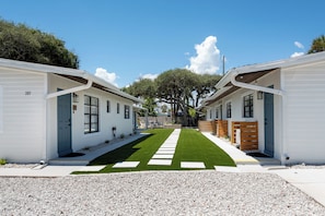 A row of white mobile homes with a central pathway. - Wave · Beach days & game nights | 1BR (Cocoa Beach)