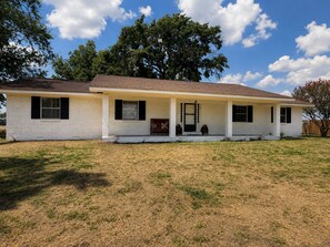 A single-story house with a front porch, a covered entryway, and a small front yard.