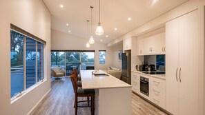 A modern kitchen with a large island, built-in appliances, and a view to the outdoors. - Bay Lookout @ Cape Villas (Dunsborough)