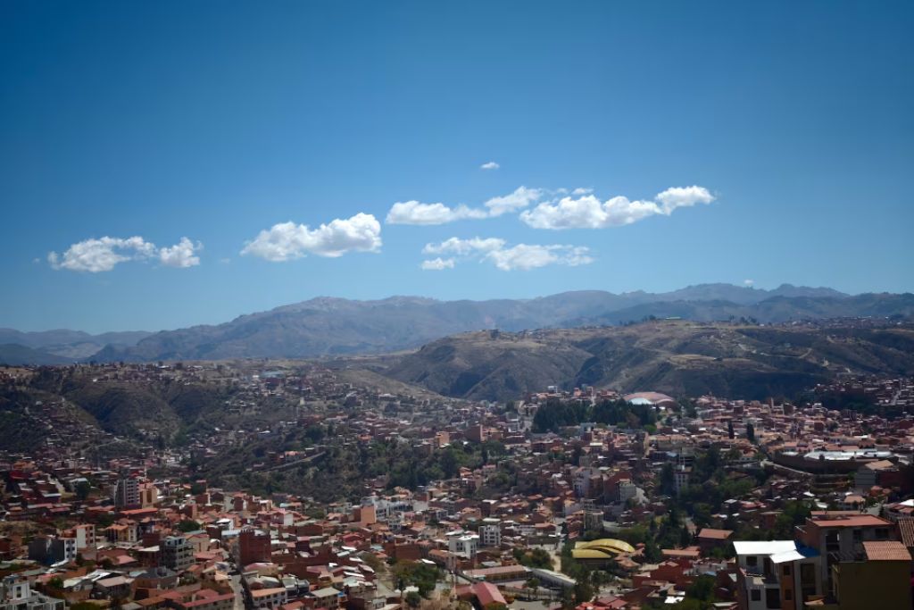 A panoramic view of a city with a mountainous backdrop.
