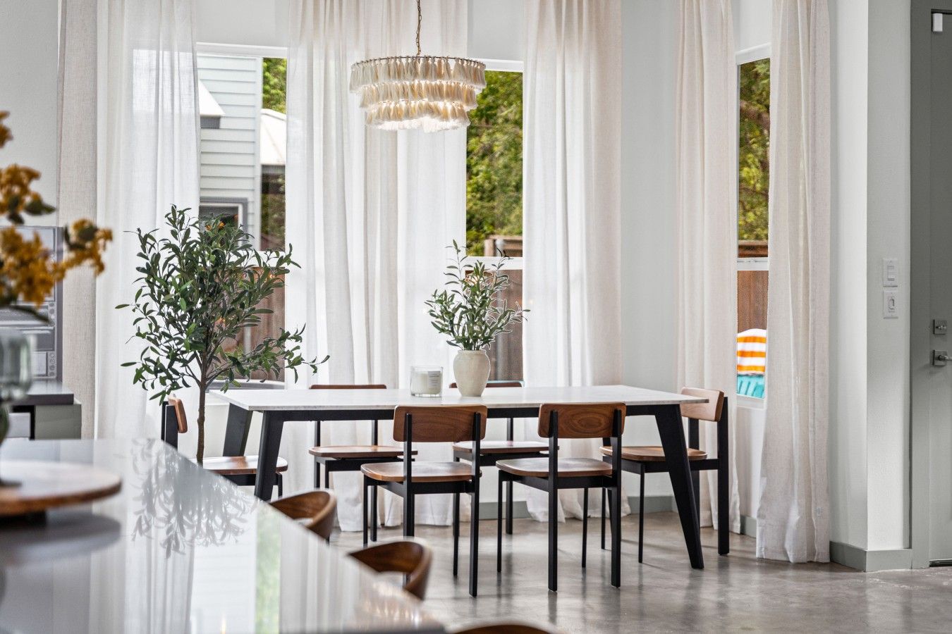 A dining area with a table, chairs, and a chandelier.