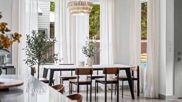 A dining area with a table, chairs, and a chandelier.