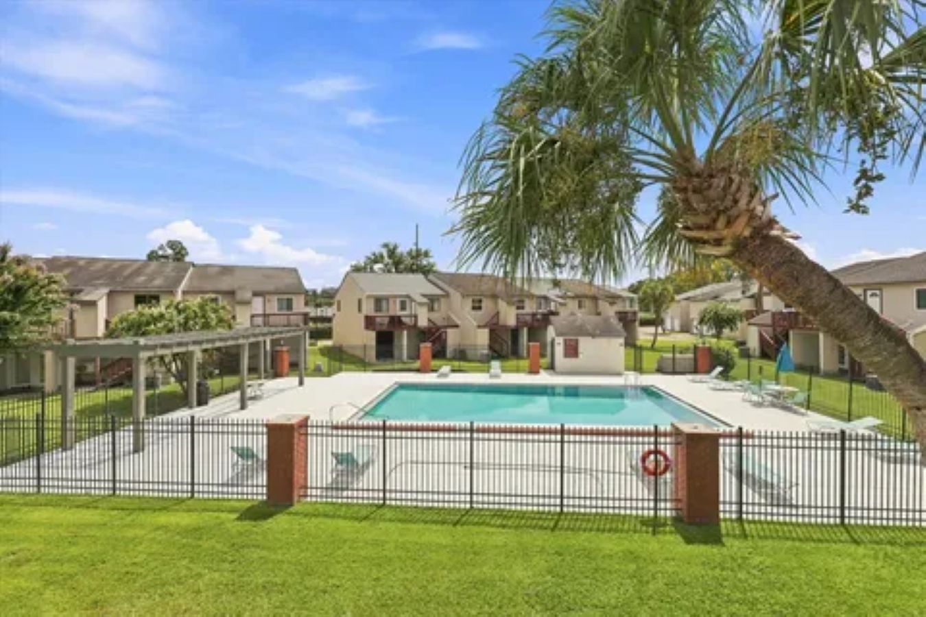 Área residencial com piscina, casas e um quintal cercado.