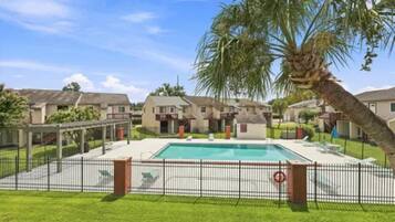 Área residencial com piscina, casas e um quintal cercado.