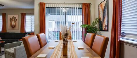 A dining area with a wooden table, leather chairs, a woven placemat, and a decorative vase.