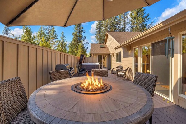 An outdoor patio with a round table, chairs, a fire pit, and a barbecue grill. - AC, Luxury, Comfort, Family, Hot tub, Privacy (Sunriver)