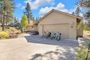 A single-story building with a garage, a driveway, and a row of bicycles parked outside. - AC, Luxury, Comfort, Family, Hot tub, Privacy (Sunriver)