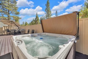 A hot tub on a wooden deck with a beige fence and trees in the background. - AC, Luxury, Comfort, Family, Hot tub, Privacy (Sunriver)