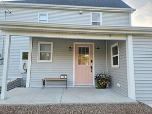 A two-story house with a front porch, a pink door, and a number '70' sign.
