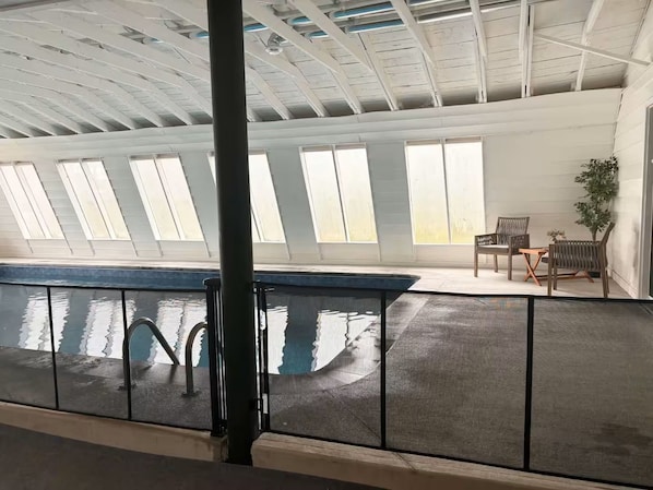 An indoor swimming pool with a clear view of the ceiling and windows.
