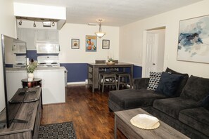 A compact living space with a kitchenette, dining area, and a sofa.