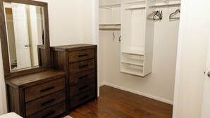 A walk-in closet with a wooden dresser and a full-length mirror. - Tranquil 2-bedroom townhome with AC in charming Troy (Troy)