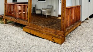Ein eingeschossiges Gebäude mit einer Holzterrasse und einer Veranda.