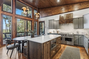 A modern kitchen with a large island, built-in appliances, and a view of the outdoors. - Mountain-Modern Blue Ridge Retreat with Sauna, Hot Tub & Year-Round Views (Blue Ridge)