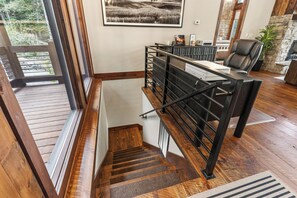 A wooden staircase with a metal handrail leading to a landing area. - Mountain-Modern Blue Ridge Retreat with Sauna, Hot Tub & Year-Round Views (Blue Ridge)