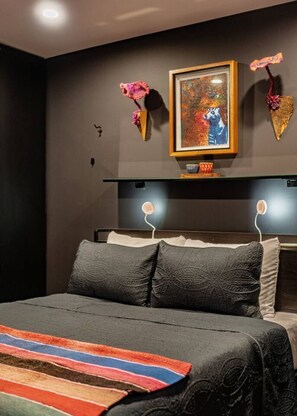 A modern bedroom with a large bed, dark walls, and a framed painting above the bed. - Combo Suites: 4BR, Gym, Rooftop & Coworking (Mexico City)
