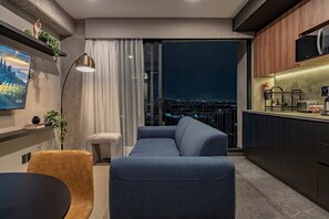 A modern living room with a sofa, a small table, a floor lamp, and a painting on the wall. - Boutique 1BR Suite Near Reforma (Mexico City)