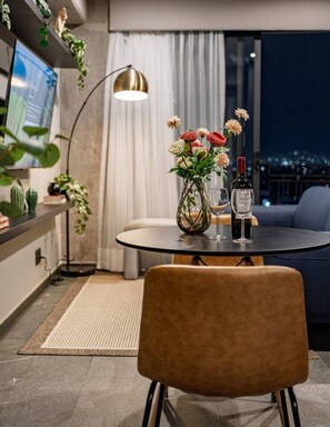 A modern living room with a round table, a sofa, a floor lamp, and a TV. - Boutique 1BR Suite Near Reforma (Mexico City)