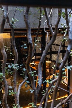 A room with a bed, a nightstand, and a window with a view of trees. - Walk to Cafés, Parks & Restaurants | Roma Norte (Mexico City)