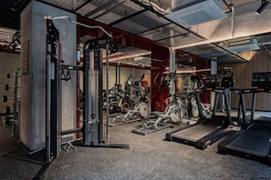 Ein Fitnessstudio mit Cardiogeräten, Krafttrainingsgeräten und Laufbändern.
