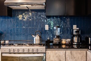 A kitchen with a gas stove, a kettle, a blender, a coffee maker, and a toaster. - Balsas Urban Escape | Near Reforma (Mexico City)