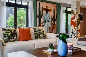 A living room with a sofa, a coffee table, and a painting of a figure with a hat. - Balsas Urban Escape | Near Reforma (Mexico City)