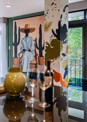 A room with a large painting of a seated figure, a cactus, and abstract art on the wall. - Balsas Urban Escape | Near Reforma (Mexico City)