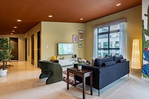 A modern living room with a sofa, a dining table, a TV, and a large window. - Serene CDMX Stay | Modern (Mexico City)