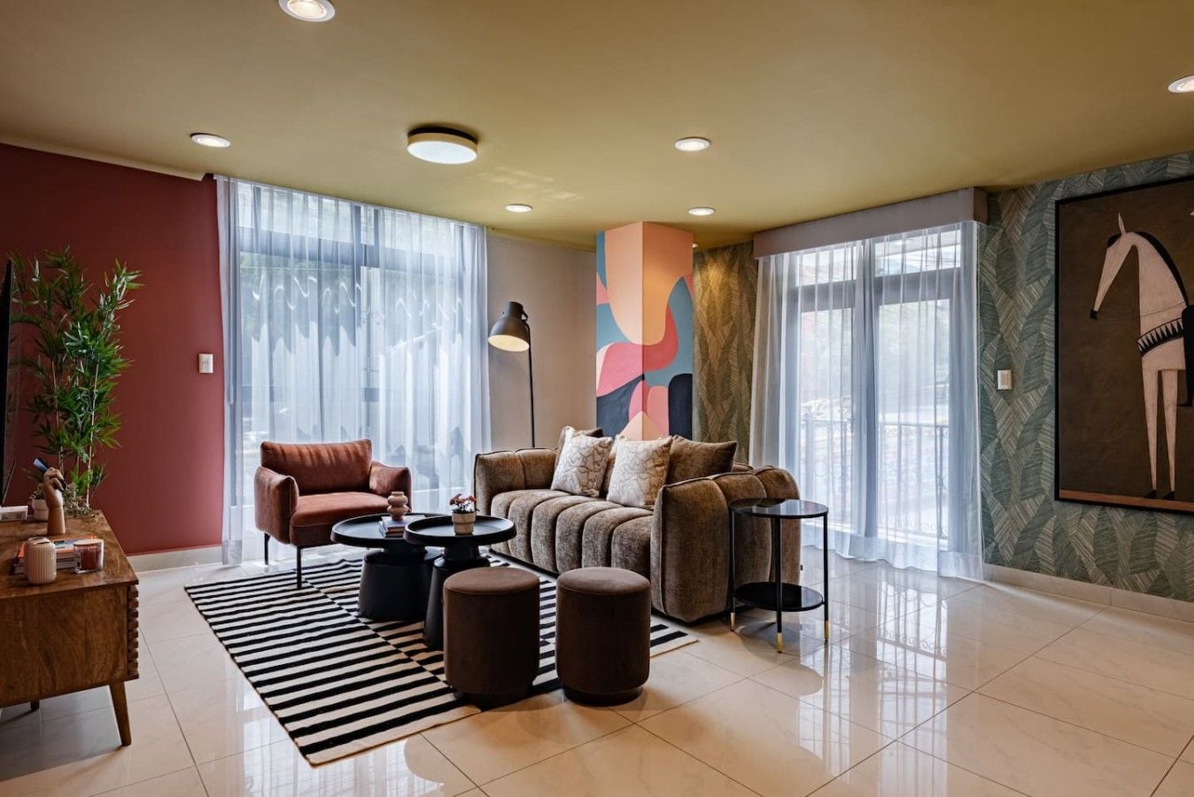 A modern living room with a sofa, armchairs, a coffee table, and a rug.
