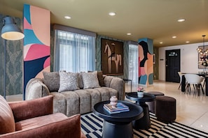 A modern living room with a sofa, armchairs, a coffee table, and a dining area with a table and chairs. - Retro-Modern Retreat Near Reforma (Mexico City)