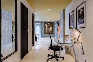 A modern office space with a glass desk, black office chair, and a painting on the wall. - Retro-Modern Retreat Near Reforma (Mexico City)