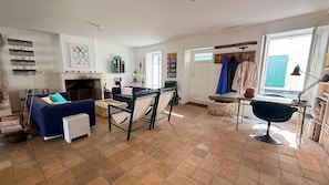 A living room with a fireplace, a sofa, a dining table, and a chair. - Two-story village house in the village of Ars (ARS EN RE)
