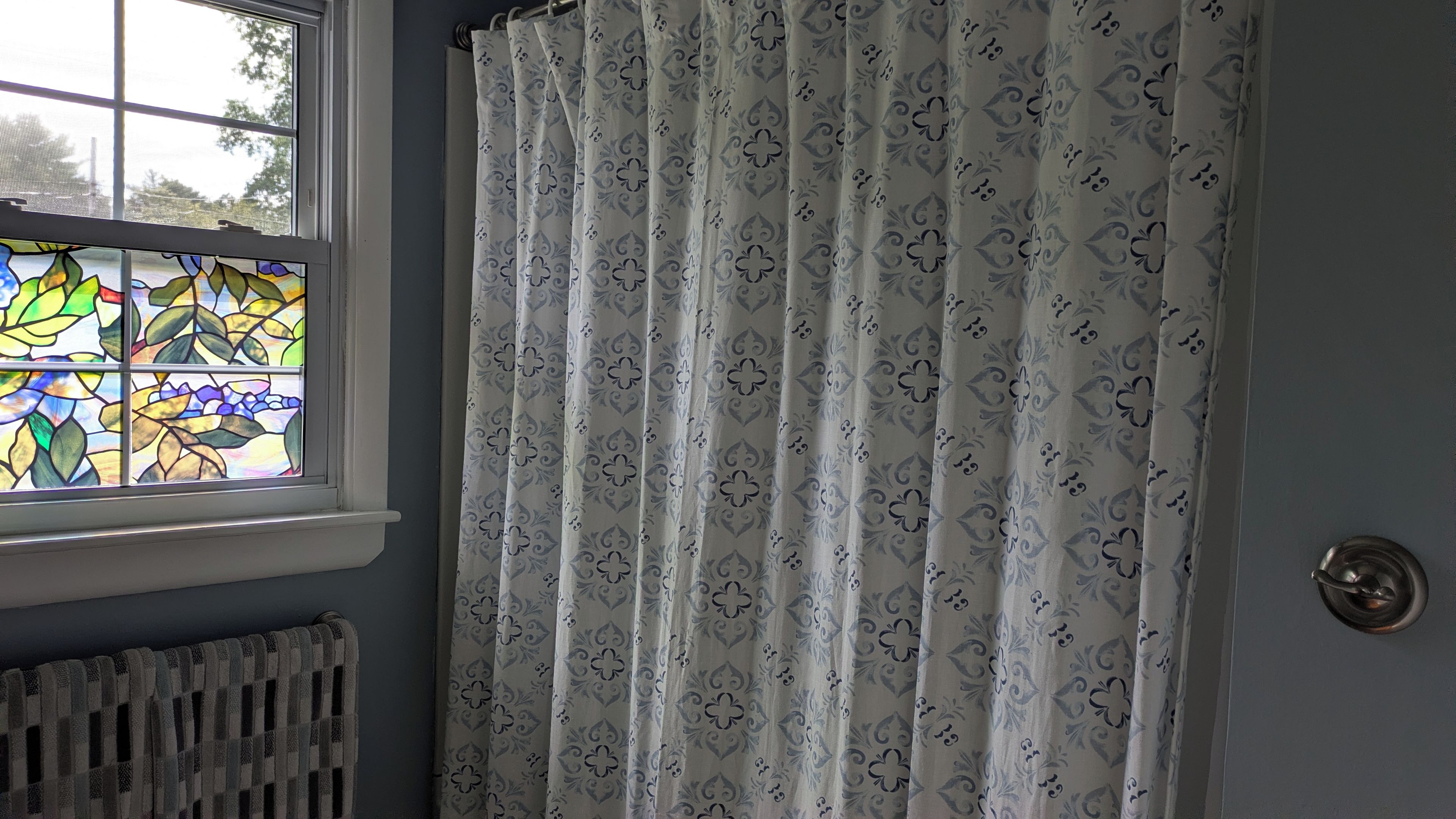 A room with a window, a radiator, and a door with a round handle.