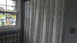 A room with a window, a radiator, and a door with a round handle.