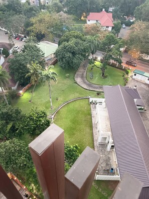 A residential area with a curved driveway, a lawn, and a house with a red roof. - Cozy 1-bedroom apartment in beautiful Accra with AC and gym (Accra)