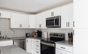 A modern kitchen with white cabinets, a stainless steel microwave, a built-in oven, and a dishwasher. - Modern Scottsdale/PHX Getaway, Private Heated Pool - Minutes to Golf & Shopping (Phoenix)