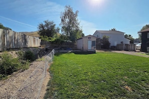 A backyard with a wooden fence, a small shed, and a house. - Entire Upper Floor by ISU • Fenced Yard • Dogs OK (Pocatello)