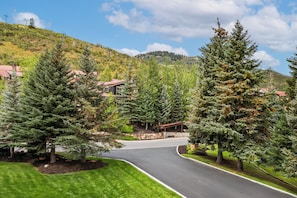 A residential area with a curved road, houses with red roofs, and a mountain backdrop. - Park City-Kings Heaven: Steps to Silver Star Lift /Hot Tub, XC Skiing & Golf (Park City)