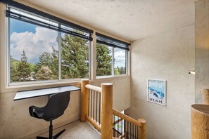 A room with a desk, a chair, a wooden railing, and a poster on the wall. - Park City-Kings Heaven: Steps to Silver Star Lift /Hot Tub, XC Skiing & Golf (Park City)