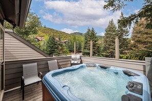 A hot tub on a wooden deck with a view of a forested hillside. - Park City-Kings Heaven: Steps to Silver Star Lift /Hot Tub, XC Skiing & Golf (Park City)