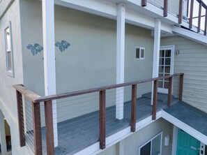 Un immeuble à plusieurs étages doté d’un balcon, d’une petite fenêtre et d’une porte.
