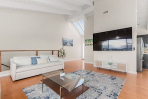 A modern living room with a sofa, coffee table, and artwork on the walls. - Modern 3BR La Jolla Home w/ Panoramic Ocean Views (La Jolla)