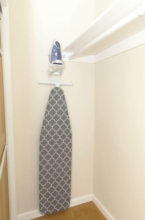 A corner of a room with a hanging iron on a white wall, a wooden floor, and a white door. - Modern 3BR La Jolla Home w/ Panoramic Ocean Views (La Jolla)