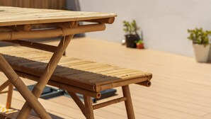 A bamboo table and bench on an outdoor deck with a view of a cityscape. - Stay at SuCaSa in Coimbra (Coimbra)