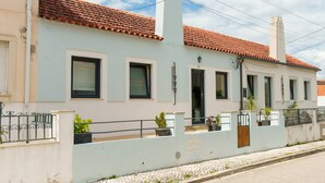 A two-story building with a tiled roof, multiple windows, and a balcony with potted plants. - Stay at SuCaSa in Coimbra (Coimbra)