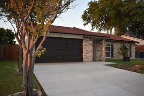 Ein Wohnhaus mit Garage, Backsteinfassade und Vordergarten.